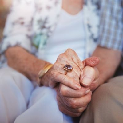 elderly couple holding hands